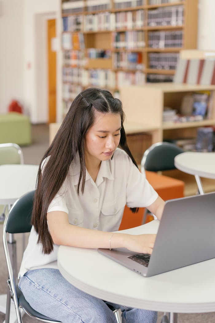 Woman in White Button Up Shirt Sitting on Chair in Front of Laptop